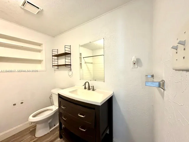 a bathroom with a sink toilet and mirror