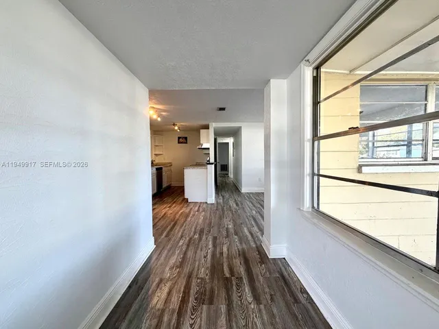 a view of a bedroom with wooden floor and a window