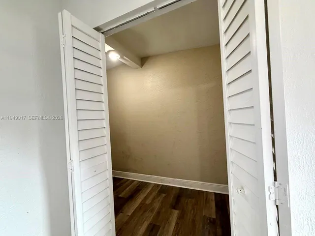 a view of a room with wooden floor and a window