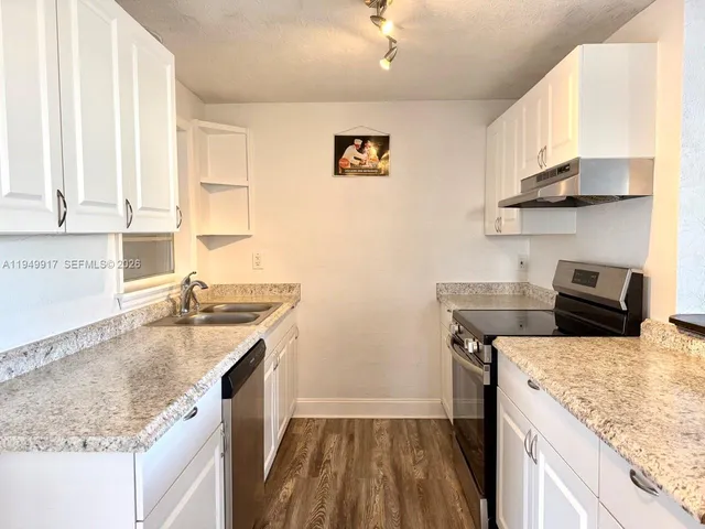 a kitchen with a sink stove and cabinets