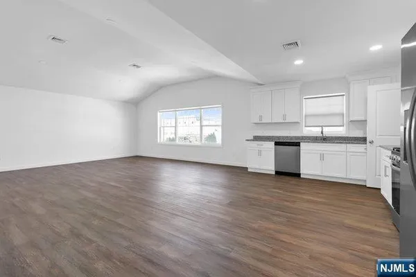 a view of kitchen with sink wooden floor and window