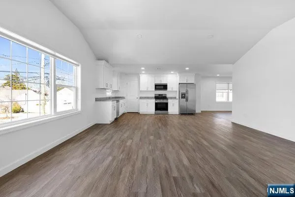 a view of empty room with wooden floor and window