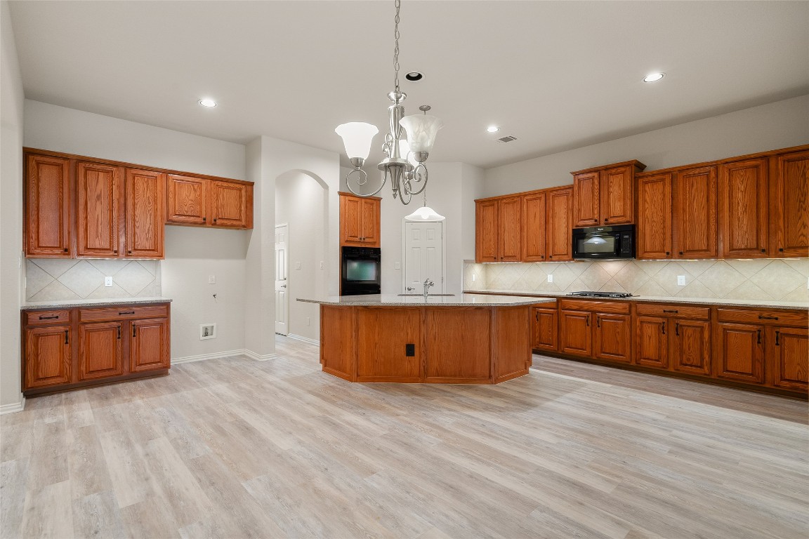 Kitchen featuring decorative backsplash, brown cabinets, decorative light fixtures, and recessed​​‌​​​​‌​​‌‌​‌‌​​‌​​​​‌​​​‌‌​‌‌‌ lighting