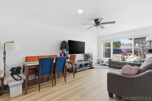 a living room with furniture a flat screen tv and a floor to ceiling window