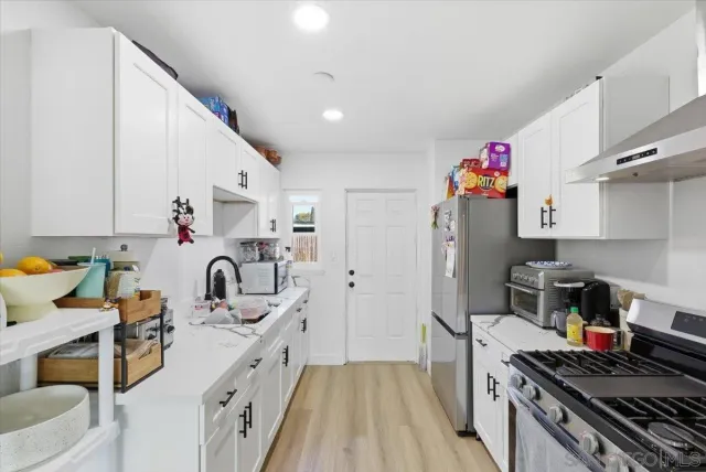 a kitchen with sink a stove and cabinets