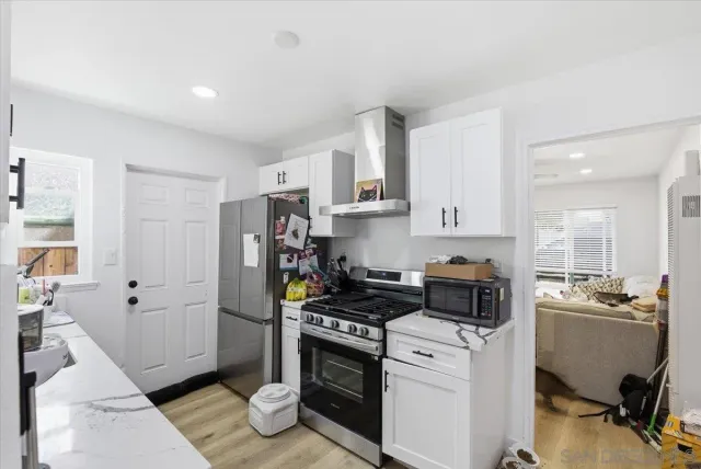 a kitchen with a refrigerator and a stove top oven