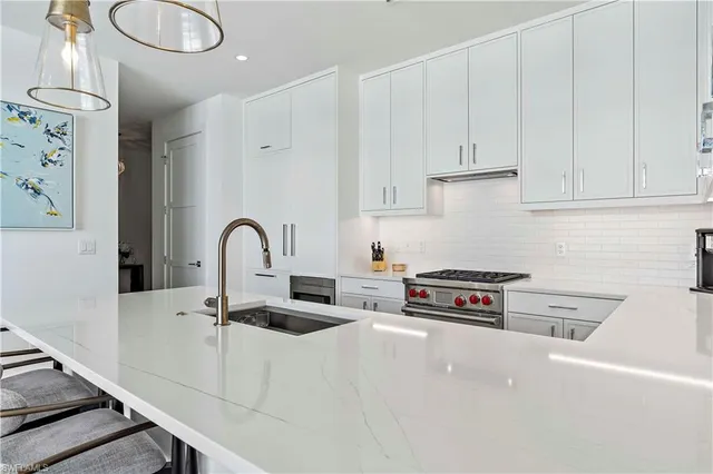 a kitchen with stainless steel appliances a sink a stove and a wooden cabinets