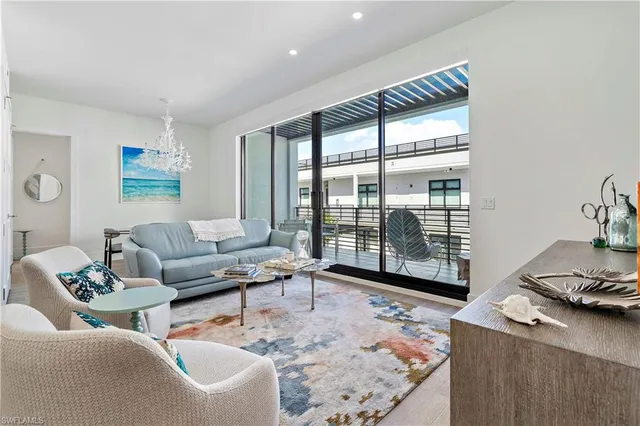 a living room with furniture and a floor to ceiling window