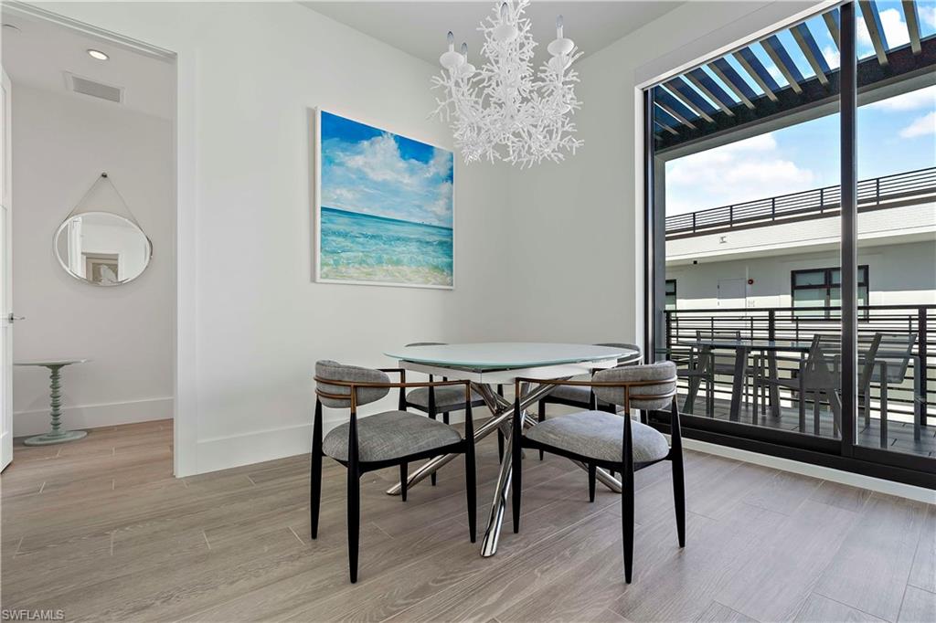 850 Central Avenue, Unit 310 Naples, FL 34102 - Photo 8 of 21 a view of a dining room with furniture window and wooden floor
