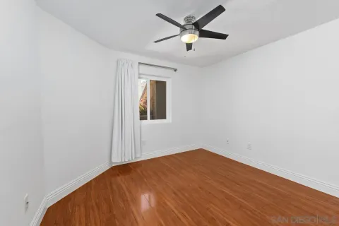 an empty room with a window and ceiling fan