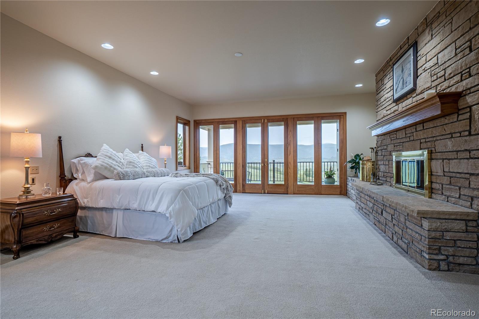 3282 Tomah Road Larkspur, CO 80118 - Photo 23 of 35 a spacious bedroom with a large bed and a large window