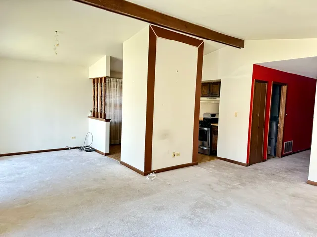 a view of a hallway with entryway windows and a kitchen view