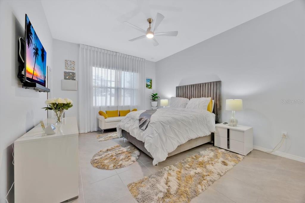 2031 Key Bay Trail Kissimmee, FL 34747 - Photo 14 of 46 a bedroom with a bed a couch and a flat tv screen on the dresser