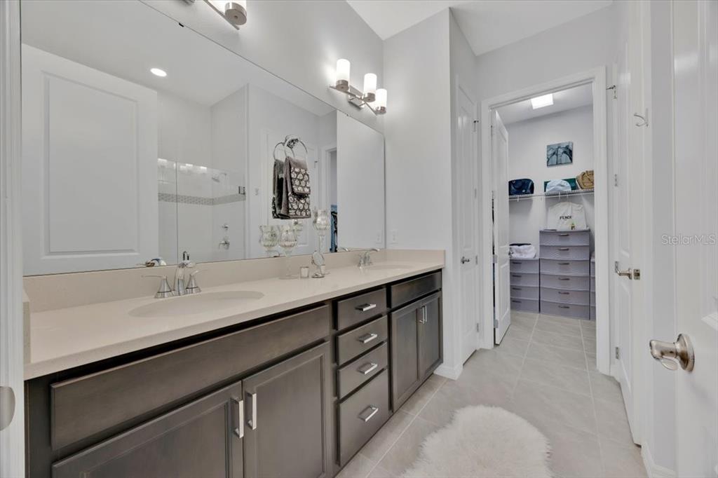 2031 Key Bay Trail Kissimmee, FL 34747 - Photo 16 of 46 a bathroom with a sink a vanity a large mirror and a shower