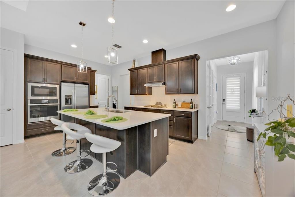 2031 Key Bay Trail Kissimmee, FL 34747 - Photo 7 of 46 a kitchen with stainless steel appliances kitchen island granite countertop a sink and cabinets