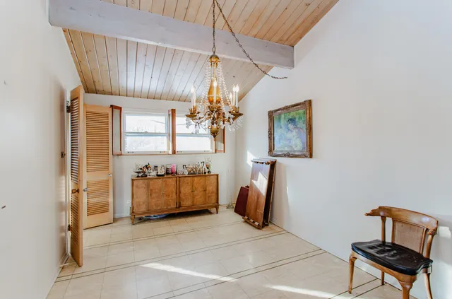 a room with chandelier and a chair