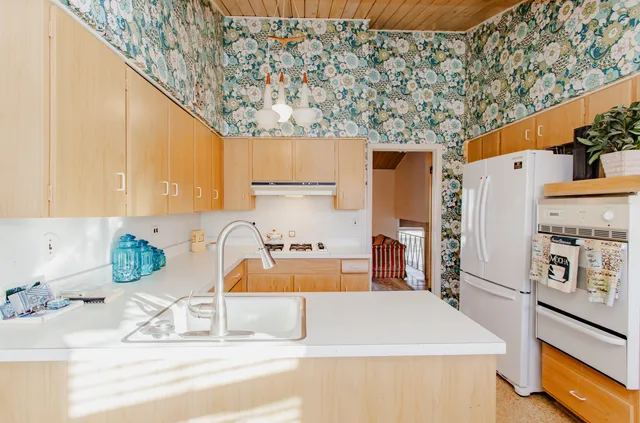 a kitchen with stainless steel appliances granite countertop a refrigerator a stove and a sink with wooden floor