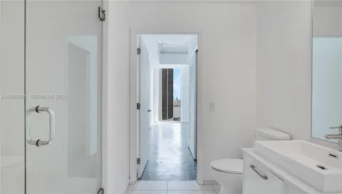 a bathroom with a granite countertop toilet a sink and mirror
