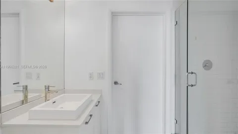 a bathroom with a sink a mirror and shower