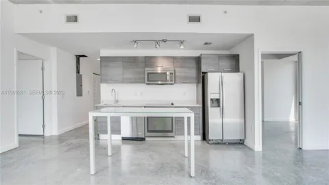 a kitchen with stainless steel appliances a stove refrigerator and cabinets