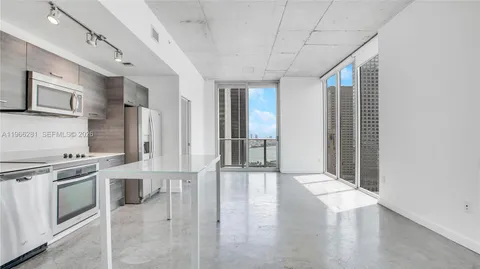a view of a kitchen with stainless steel appliances granite countertop a stove and a refrigerator