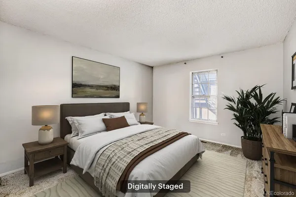 a bedroom with a bed a mirror and a potted plant