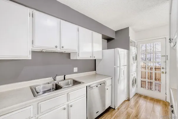 a kitchen with a sink a refrigerator and cabinets