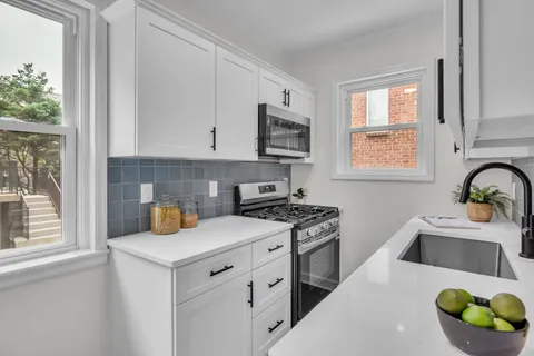 a kitchen with granite countertop a stove a sink and a microwave