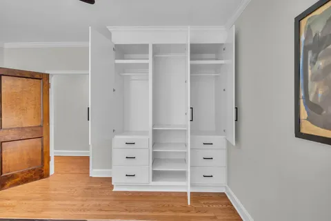 a view of walk in closet with empty racks