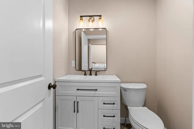 a bathroom with a toilet a sink and mirror