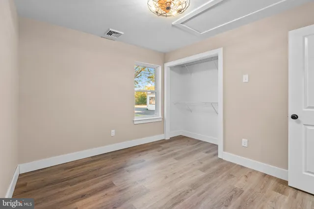 an empty room with windows and closet
