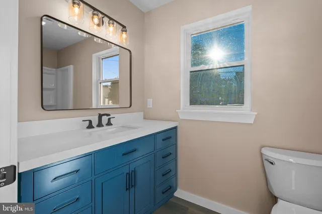 a bathroom with a toilet sink and mirror
