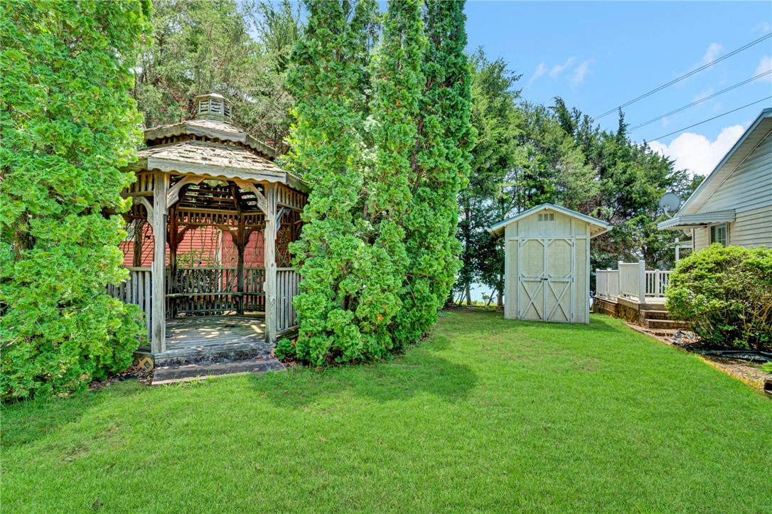 225 Nicholson Cove Road Seneca, SC 29672 - Photo 6 of 22 An inviting backyard oasis offers a classic wooden gazebo and a practical storage shed.