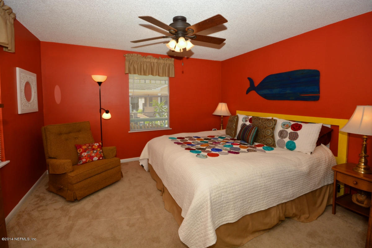 81 Kings Ferry Way St. Augustine, FL 32084 - Photo 14 of 24 a bedroom with a bed and a chandelier