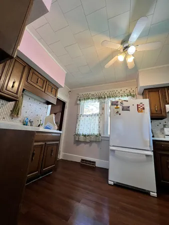a kitchen with kitchen island a wooden floor and a refrigerator