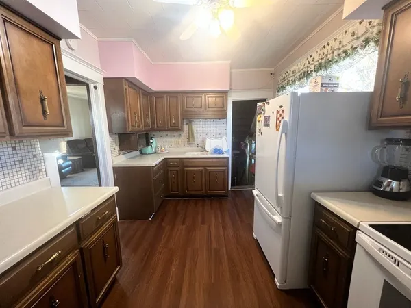 a kitchen with a sink a refrigerator a stove a washer dryer and cabinets