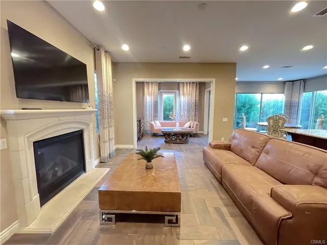 a living room with furniture a flat screen tv and a fireplace