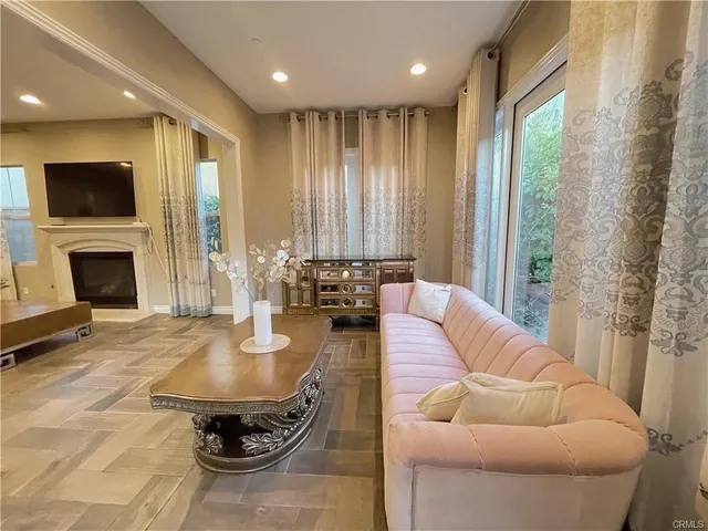 a living room with furniture a flat screen tv and a fireplace