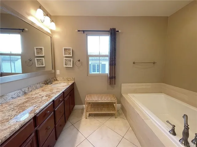 a spacious bathroom with a granite countertop tub sink and mirror