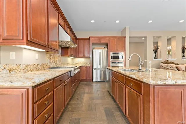 a kitchen with stainless steel appliances granite countertop a sink and cabinets