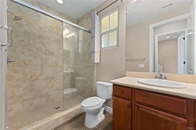 a bathroom with a sink a toilet and shower