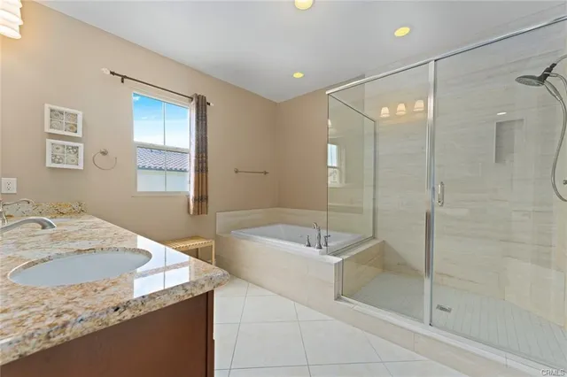 a bathroom with a granite countertop sink a toilet and shower