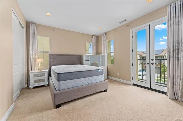 a spacious bedroom with a large bed and a chandelier