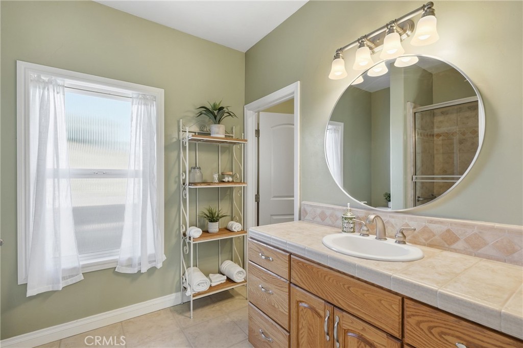 220 Cook Court Templeton, CA 93465 - Photo 23 of 45 a bathroom with a granite countertop sink a mirror and a shower