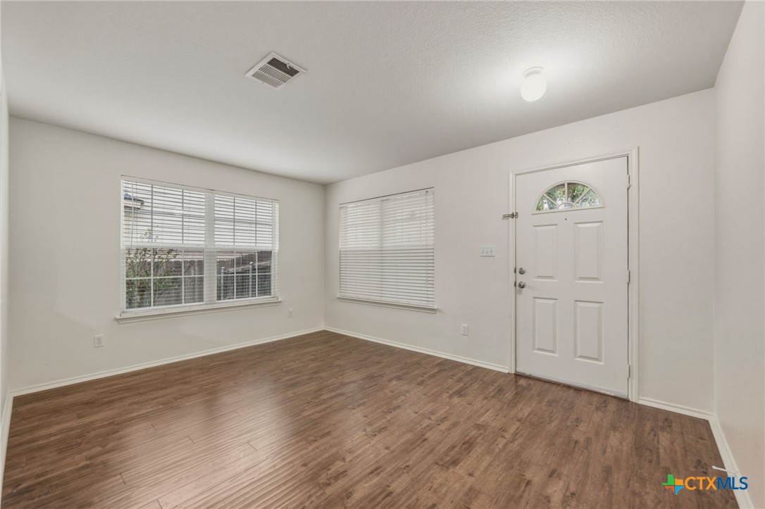 109 Comal Cove Elgin, TX 78621 - Photo 4 of 34 a view of an empty room with wooden floor and a window