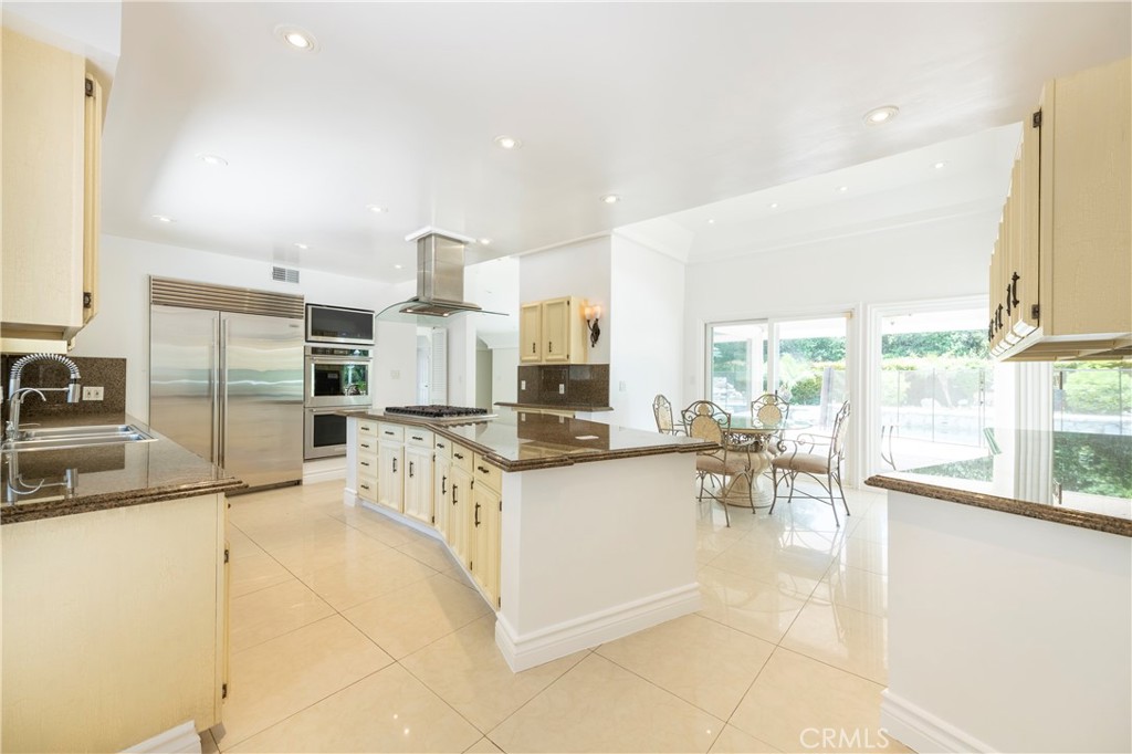 16379 Meadow Ridge Road West Encino, CA 91436 - Photo 12 of 40 a kitchen with stainless steel appliances kitchen island granite countertop a stove and a sink