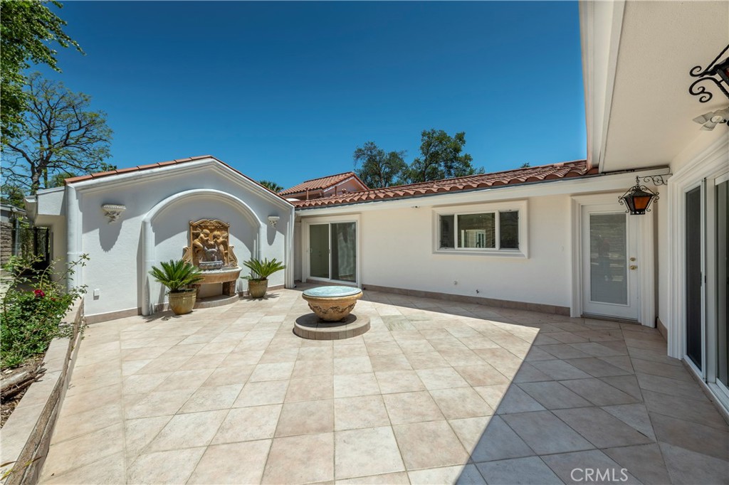 16379 Meadow Ridge Road West Encino, CA 91436 - Photo 17 of 40 a view of a house with patio and a garden