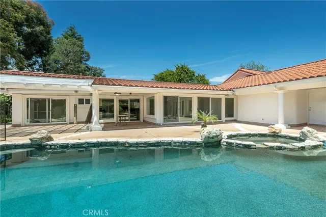 a front view of a house with a garden and swimming pool