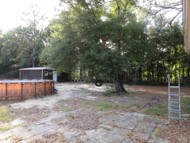 a view of a backyard with wooden fence