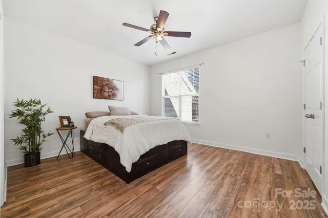 a spacious bedroom with a bed and a potted plant